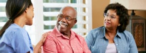 Young medical professional talking with an Elder Service Plan participant and his wife