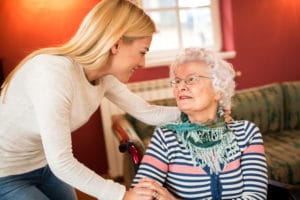 Young female caregiver chatting with an elderly woman