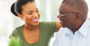 Young female caregiver listening to an elderly man